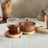 قندان چوبی کوتاه از جنس چوب راش در کنار یک لیوان چای در یک سینی قرار گرفته است.