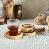  قندان چوبی کوچک از چوب گردو در کنار یک لیوان چایی و سینی چوبی