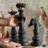 مجسمه مهره شاه شطرنج در دست نگاه داشته شده است.