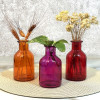 نمایی از سه رنگ قرمز صورتی و نارنجی تیره از گلدان رنگی مدل ترنج همراه با گلهای خشک
