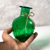 رنگ سبز از گلدان خمره ای در دست قرار دارد.