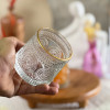  لیوان چرخشی لب طلایی در دست از نمای نزدیک
