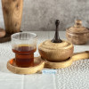 قندان چوبی متوسط از جنس چوب زبان گنجشک در کنار یک لیوان نوشیدنی چایی روی میز قرار دارند.