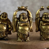 نمای نزدیک از مجسمه 3عضوی بودای خندان در حال حمل طلا