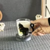 ماگ شیشه ای طرح گربه در دست